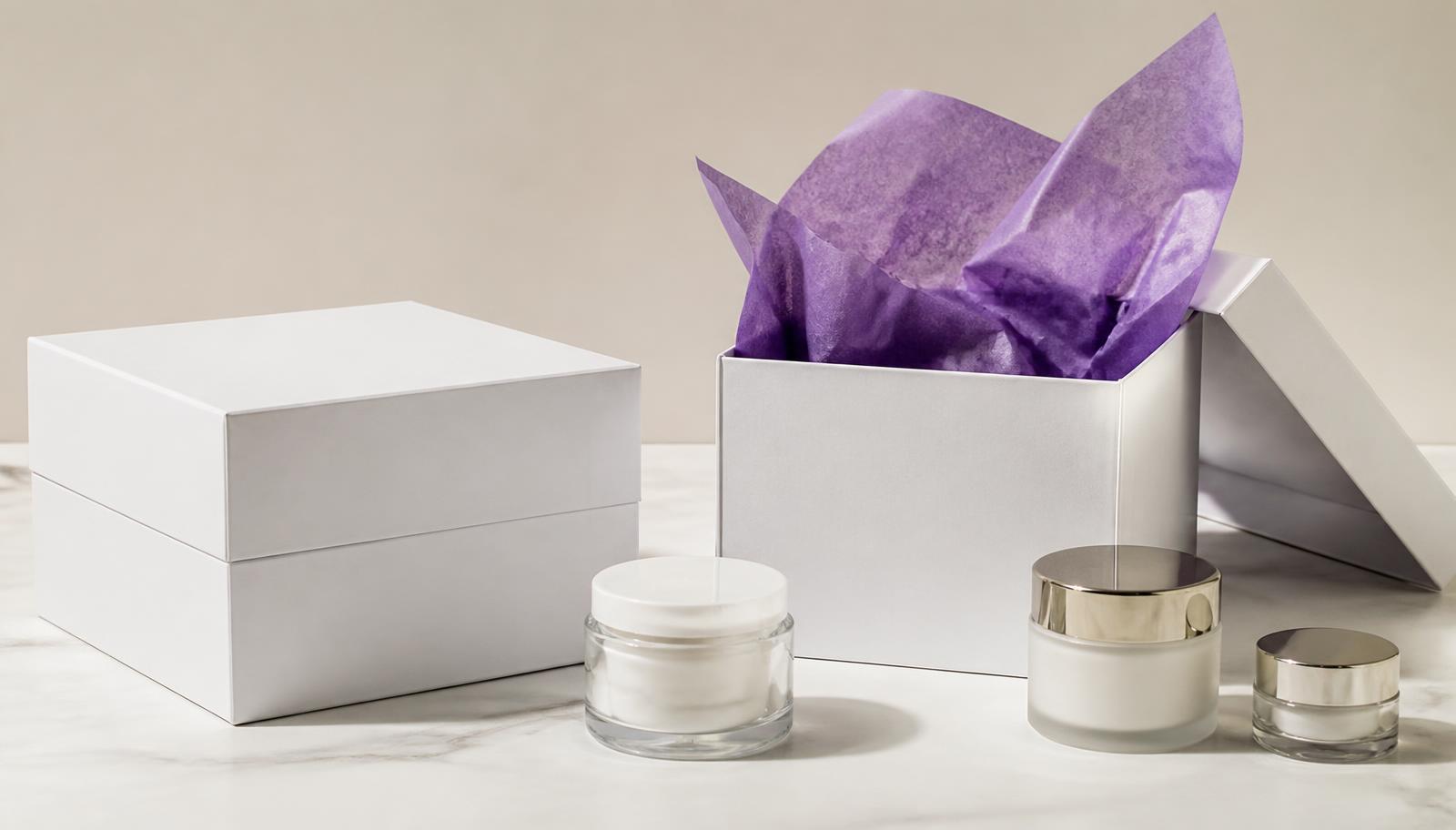 Caixa rígida branca com papel de seda e potes de cosméticos