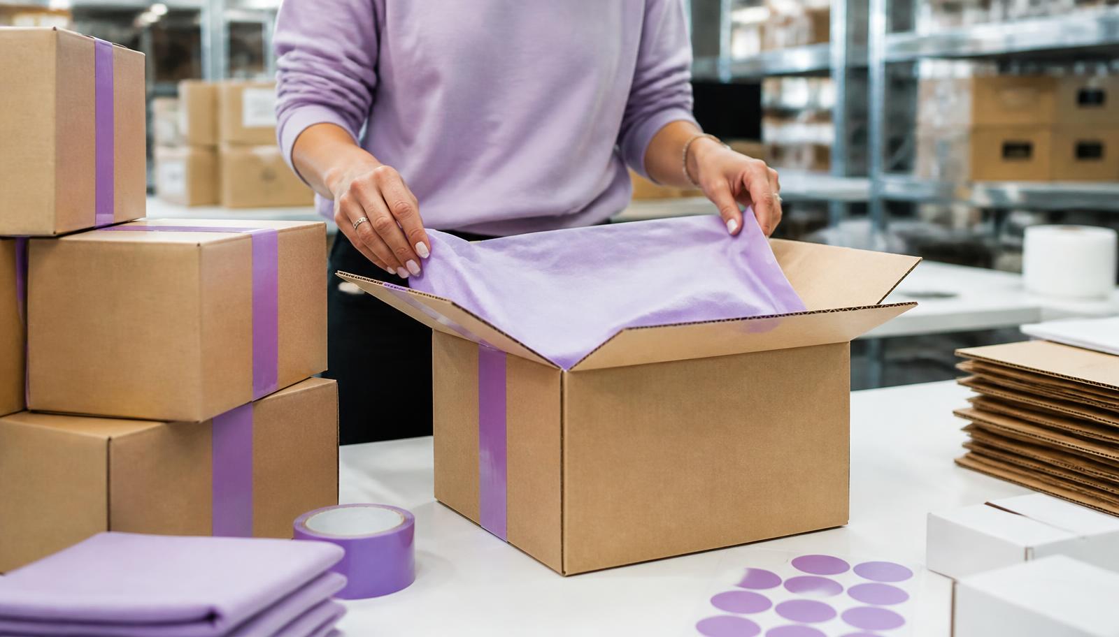 Caixas de microondulado com fita e papel de seda em mesa de expedição